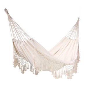 White macramé hammock with decorative fringe and a netted design at the sides, designed for hanging and lounging.