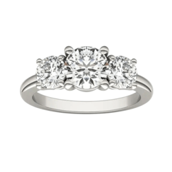 A three-stone engagement ring featuring a central round diamond flanked by two smaller round diamonds, set in a white metal band.