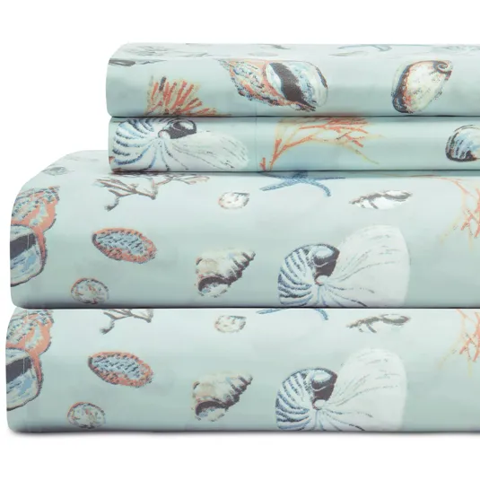 A set of bed sheets with a seashell and marine life pattern on a light background.