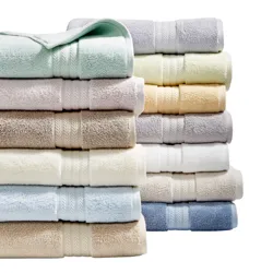 A variety of neatly stacked, colorful bath towels in pastel and neutral shades.