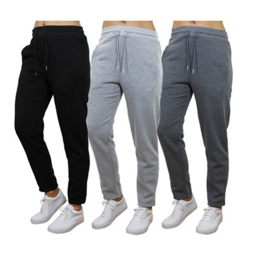 Three pairs of joggers in black, light gray, and dark gray, each with elastic waistbands, drawstrings, and white sneakers.