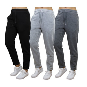 Three pairs of joggers in black, light gray, and dark gray, each with elastic waistbands, drawstrings, and white sneakers.