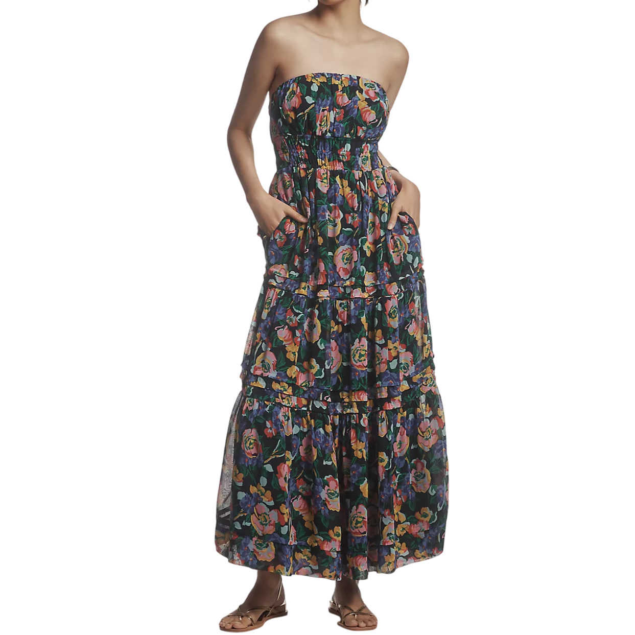 A strapless floral print maxi dress with a smocked bodice and tiered skirt, paired with tan sandals.