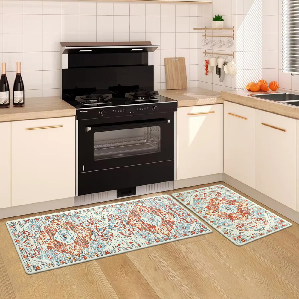 A modern kitchen features a black stove with two burners and an oven, white cabinets, wooden countertop, and two patterned kitchen mats on the floor. Bottles, cutting boards, utensils, and oranges are visible as decor.
