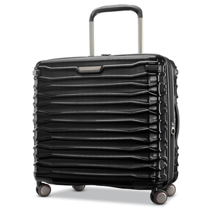 A black hard-shell suitcase with a textured, horizontal ribbed design, featuring four multi-directional spinner wheels and a telescopic handle.