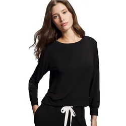 A woman wearing a black long-sleeve top paired with black pants featuring a white drawstring.