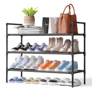 A multi-tiered shoe rack holds various footwear, including boots, sneakers, and slippers, with additional storage for magazines, shopping bags, and a handbag. A potted plant sits on top for decoration.