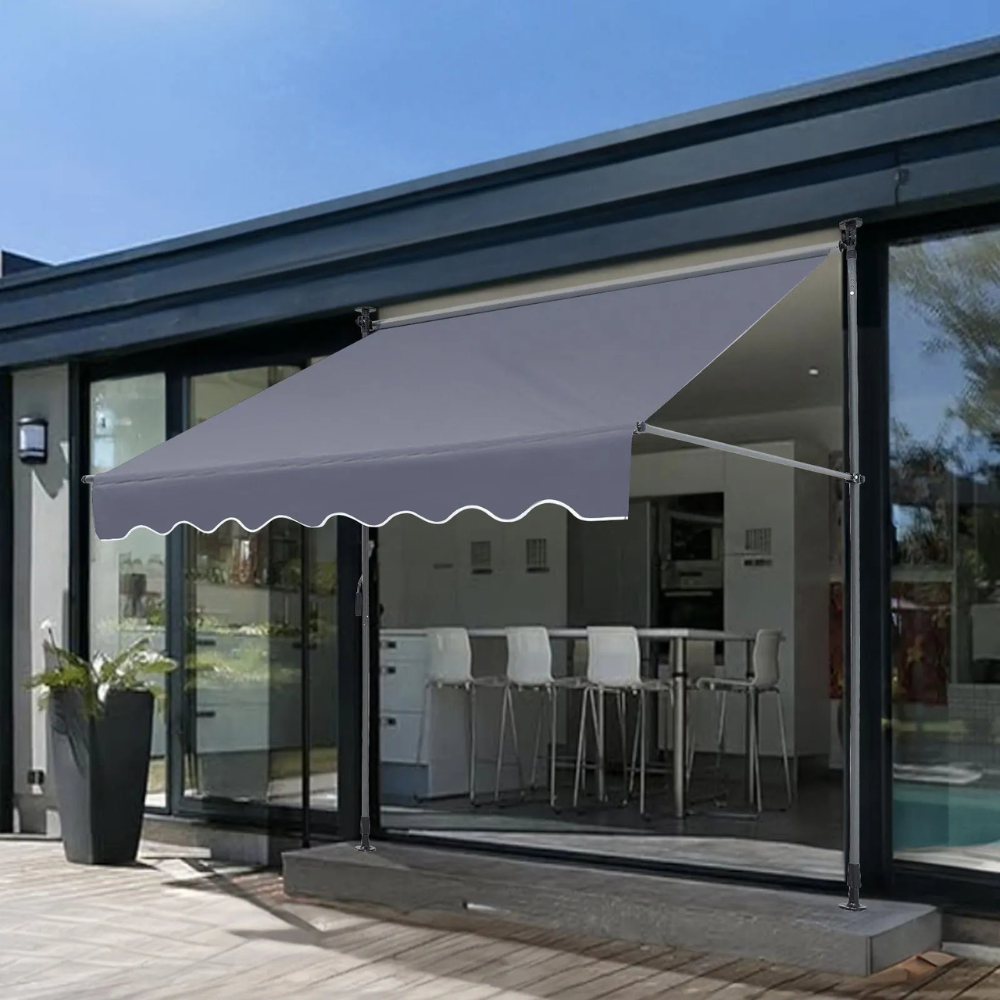 A retractable grey outdoor awning is installed above a patio door, providing shade to the patio area.