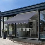 A retractable grey outdoor awning is installed above a patio door, providing shade to the patio area.