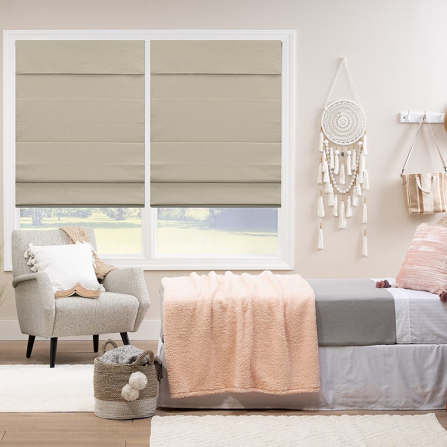 Roman shades on windows, a beige armchair, and a daybed with a pink blanket in a well-lit room.
