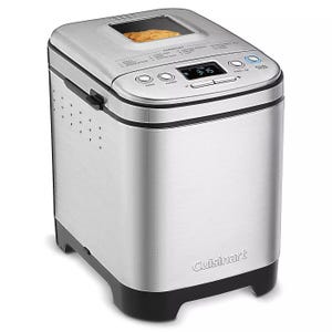 A stainless steel Cuisinart bread maker with a viewing window on top, digital control panel with preset options, and a sturdy black base.