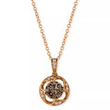 A gold-tone necklace featuring a round pendant with a central cluster of dark stones surrounded by white accent stones on an intricate open design.