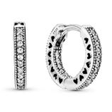 Sterling silver hoop earrings with heart-shaped cutouts and two rows of clear cubic zirconia stones; stamped S925.