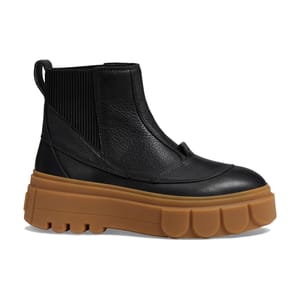 Black leather ankle boots with a thick, ribbed elastic side panel and a chunky, contrasting brown rubber sole with a treaded bottom for grip.