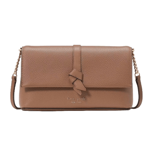 A tan leather crossbody bag featuring a knotted flap closure, gold chain strap, and \“kate spade NEW YORK\“ embossed logo on the front.