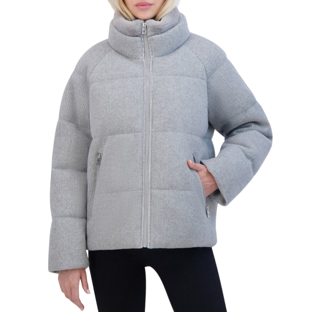 A gray, padded puffer jacket with a high collar, full front zipper, and zippered side pockets, paired with black pants.