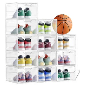 A stack of transparent shoe storage boxes neatly organizes various pairs of colorful sneakers, with a basketball positioned beside them.
