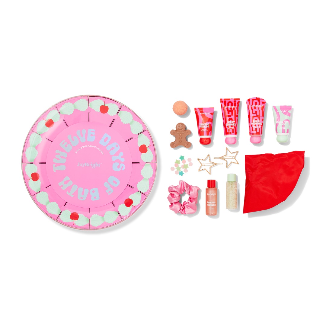 Ulta's 12 Days of Bath Advent Calendar includes various bath items like lotions, a gingerbread soap, scrub, bath bomb, scrunchie, star-shaped accessories, and a red towel. The packaging features a pink, circular design with “Twelve Days of Bath” printed on it.