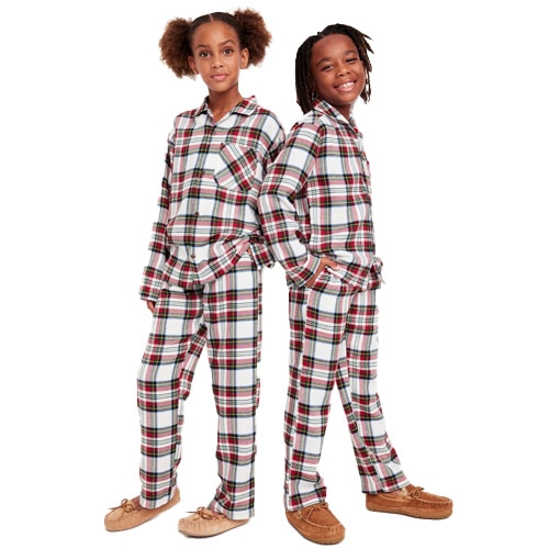Two children are wearing matching plaid button-front pajamas with long sleeves and pants, complemented by moccasin-style slippers.