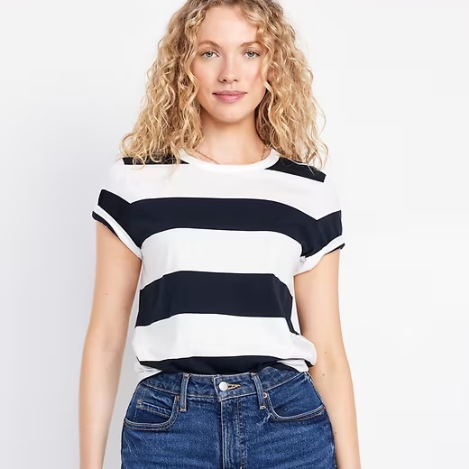 A woman wearing a striped black and white short-sleeve top paired with blue jeans.