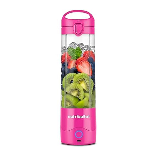 A pink NutriBullet portable blender filled with ice, strawberries, blueberries, kiwi slices, and mint leaves.