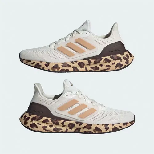 Two pairs of white running shoes with leopard print soles.