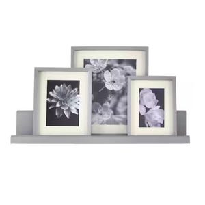 A set of three gray photo frames with black and white floral images, arranged on a shelf.
