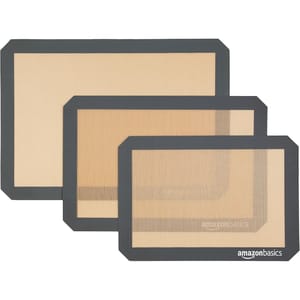 Three nested silicone baking mats in different sizes with dark gray borders, branded \“Amazon Basics.\“