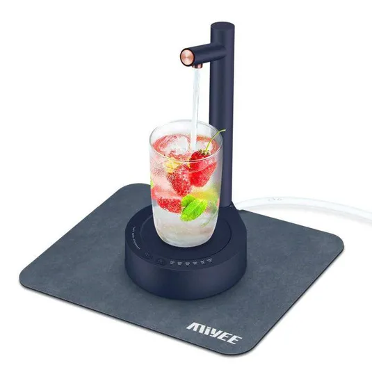 A sleek countertop water dispenser pouring water into a glass with strawberries, mint, and ice. The unit is placed on a square mat labeled \“MIVEE.\“