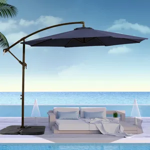A blue cantilever patio umbrella provides shade over a modern outdoor sofa set by the pool, with a background of ocean and sky.