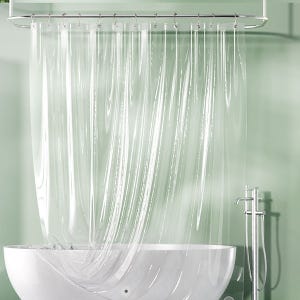 A clear shower curtain with vertical stripes attached to a silver rail above a white bathtub, with a metallic showerhead and faucet on the right.