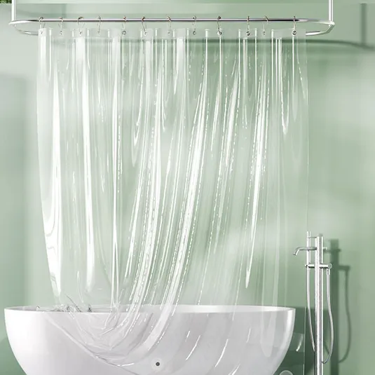 A clear shower curtain with vertical stripes attached to a silver rail above a white bathtub, with a metallic showerhead and faucet on the right.