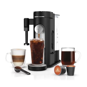 A Ninja Specialty Coffee Maker brews various coffee types, including iced coffee, and features a spout for direct dispensing. It comes with a glass of iced coffee, a cup of layered coffee, and a cup of hot coffee, alongside coffee pods and a scoop.