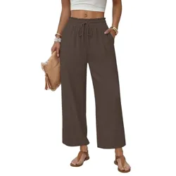 The image shows a person wearing brown wide-leg pants with an elastic waistband and drawstring. They are accessorized with sandals, bracelets, and a clutch.