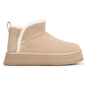 A tan suede ankle boot with a thick platform sole and a pull tab at the heel, featuring white fur trim along the opening.