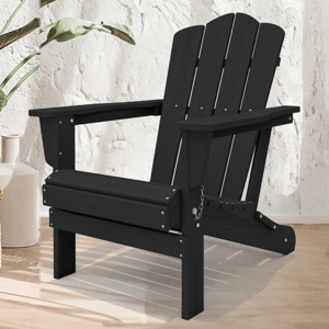 A black Adirondack chair is placed on a light wood floor next to potted plants and a white vase, set against a textured white wall.