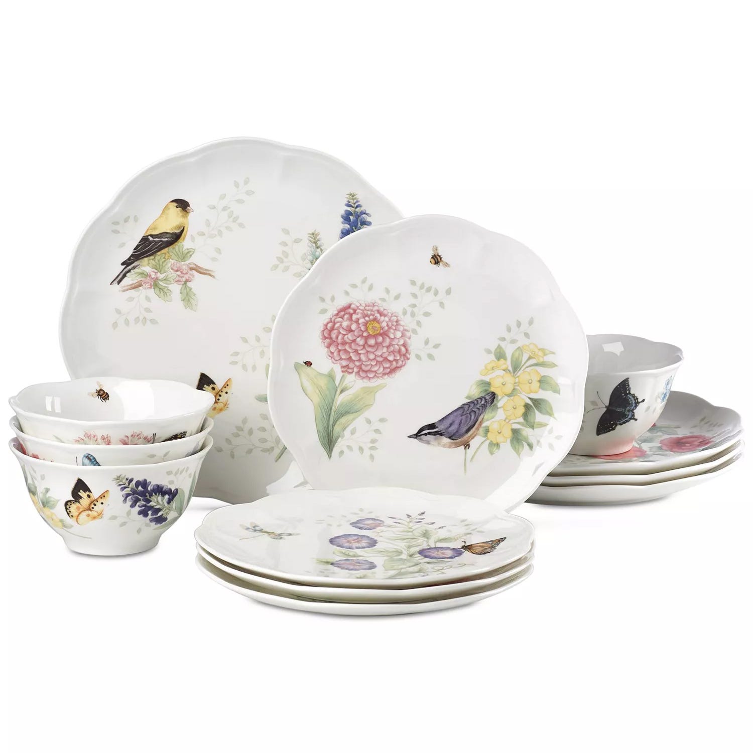 A dinnerware set featuring plates and bowls with floral and bird designs in soft pastel colors. The set includes various dishes with nature-themed illustrations.