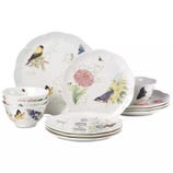 A dinnerware set featuring plates and bowls with floral and bird designs in soft pastel colors. The set includes various dishes with nature-themed illustrations.