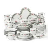 Set of holiday-themed dinnerware with red and green adornments, including plates, bowls, mugs, and serving pieces, featuring ribbon and evergreen designs.