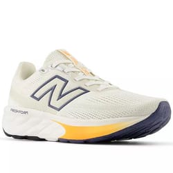 A sneaker with a cream and yellow color scheme, featuring \“N\“ branding on the side and \“Fresh Foam\“ technology on the sole.