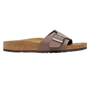 A brown Birkenstock sandal featuring a cork footbed and a single adjustable strap with a metal buckle.