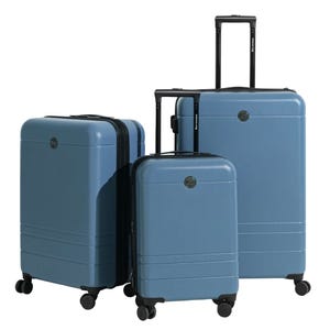 Three-piece luggage set in blue featuring hard-shell design, telescopic handles, spinner wheels, and a sleek minimalist appearance.