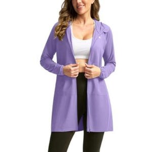 A woman wearing a long, purple hooded jacket over a white sports bra and black leggings.