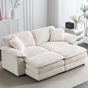 A beige corduroy sectional sofa with cushioned seats and backs, placed in a light-filled living room with decorative plants and accessories.