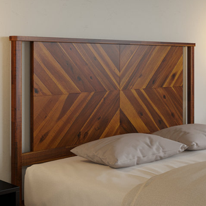 A wooden headboard with a chevron pattern design in natural tones, mounted behind a bed with two beige pillows.
