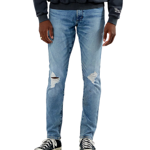 Light blue distressed jeans with ripped knee details, paired with black high-top sneakers and a dark sweatshirt.