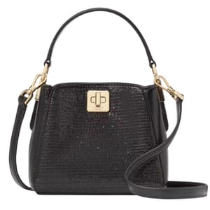 A black Kate Spade Phoebe Glitter Crossbody features a textured glittery surface with gold-tone hardware, a turn-lock closure, a detachable shoulder strap, and a top handle for versatile carrying options.