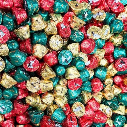 A pile of chocolate candies wrapped in red, green, and gold foil.