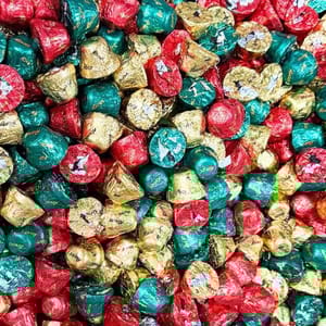 A pile of chocolate candies wrapped in red, green, and gold foil.