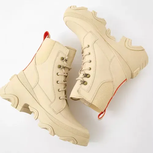 A pair of beige lace-up ankle boots with chunky soles.